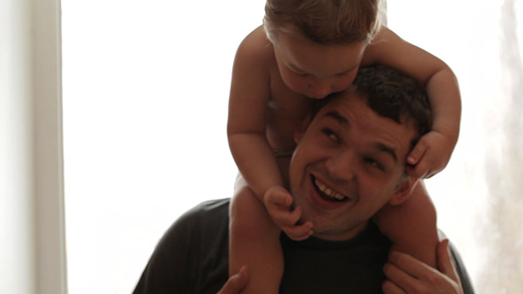 Two Year Old Son Sitting On Father's Shoulders