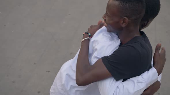 happy Young african  migrants hugging in the street - slow motion