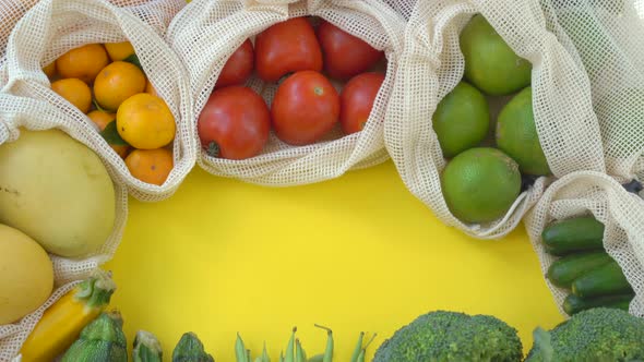 Colorful Fruits and Vegetables in Reusable Bags on a Yellow Background. Zero Waste. Reduce Plastic