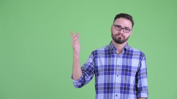Stressed Young Bearded Hipster Man Thinking and Pointing Up