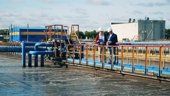 Sewage Cleaning Site with Two Inspectors Having a Discussion