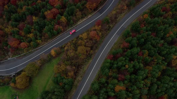 Aerial view above car driving down mountain switchback road