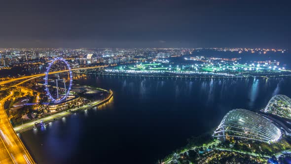 Skyline of Singapore with Famous Singapore Ferries Wheel Night Timelapse