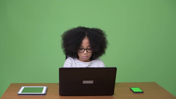 Young Cute African Girl with Afro Hair Using Laptop