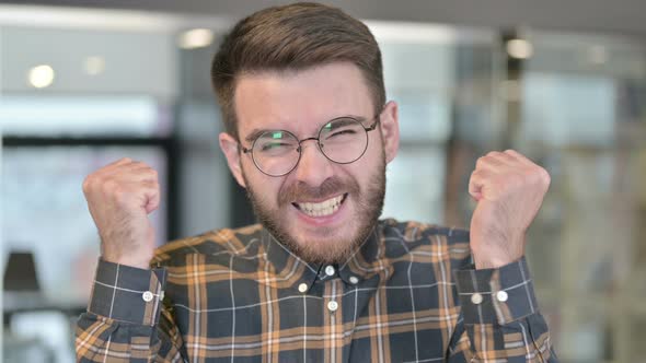 Portrait of Young Designer Celebrating Success in Office