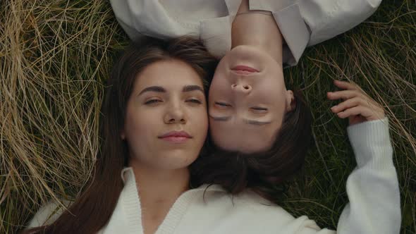 Two Relaxed Lesbians Lying Face to Face on Grass