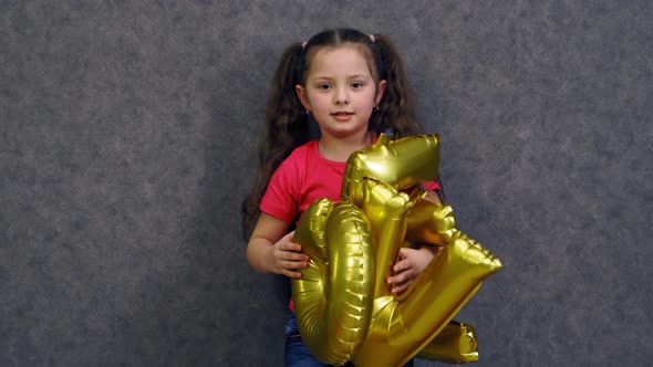 Child girl with balloons. Portrait of little girl playing with balloons