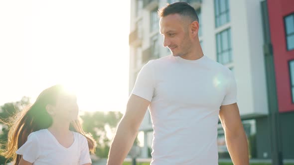 Dad and Daughter Walk Around Their Area at Sunset