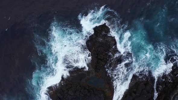 Aerial Top View of Waves Break on Rocks