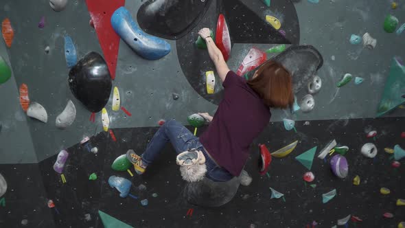 Climber Training on a Climbing Wall Female Practicing Rockclimbing Mountaineer Training Moving Up