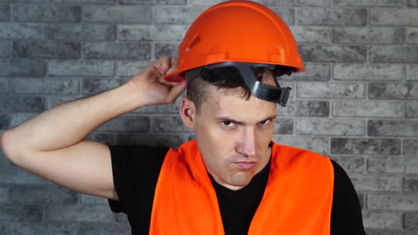 Man in Working Uniform Turning Orange Protective Hardhat