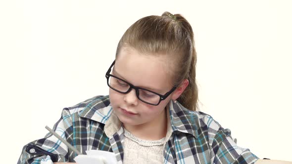 Girl Carefully Read and Write Data To the Notebook. White Background. Close Up