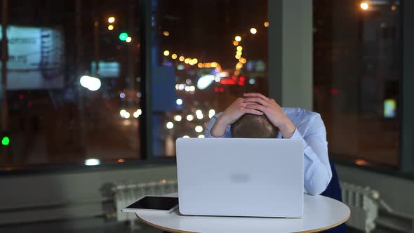 Tired Businessman Working Late at Night With Laptop in Office