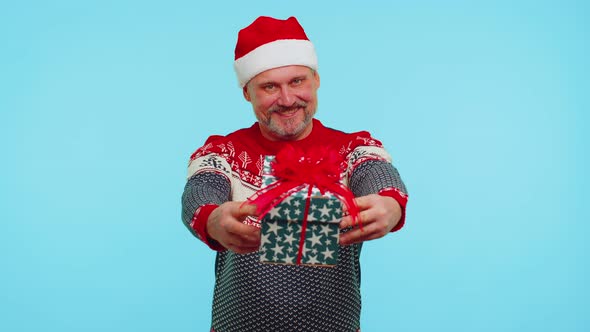 Funny Man Wears Red New Year Sweater and Hat Presenting Christmas Gift Box Shopping Sale Holidays