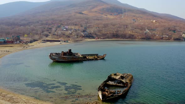 A Wrecked Wooden Ship Lies on the Seashore Covered with Rust