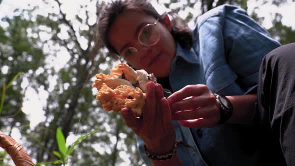 Woman with edible mushroom in hands in forest
