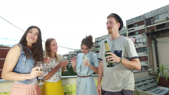 Hipster man drinking champagne with beautiful female friends