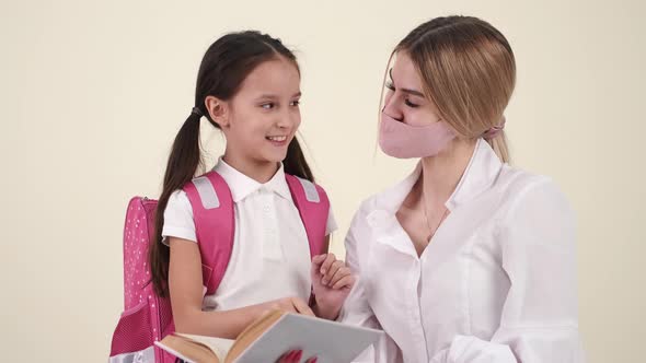 Mother and Daughter Preparing Backpack for School