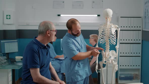 Therapist Showing Back Bones Spinal Cord to Senior Man