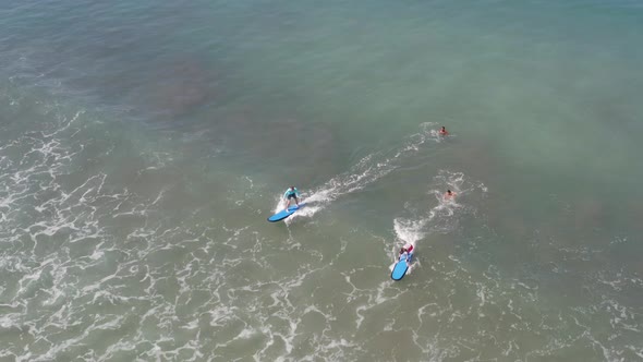 Two Beginners Surfing In Ocean Surf School. People Surfing in the Ocean of a Beautiful Beach Bali