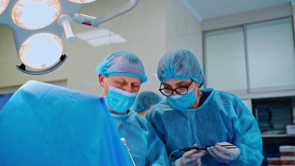 Professional nurse helps the surgeon during operation