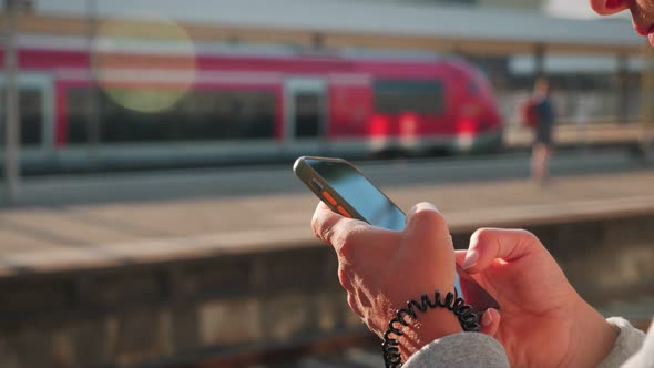 Finger of woman touching display on mobile phone