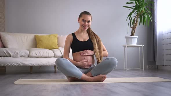 Pregnant Happy Woman Touch Belly Stroking Abdomen Sit on Mat Floor Smile Portrait Spbd