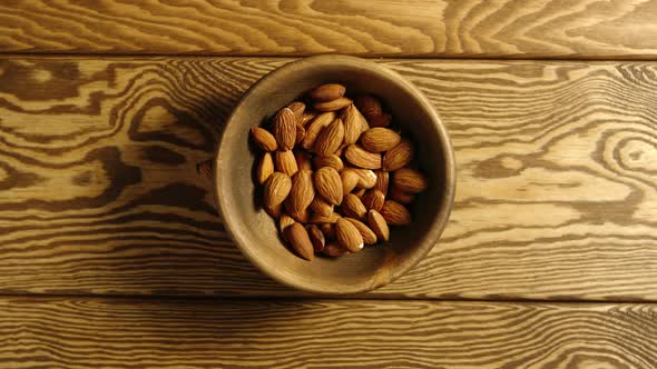 Almond Kernels Fall Into A Wooden Dish On A Table