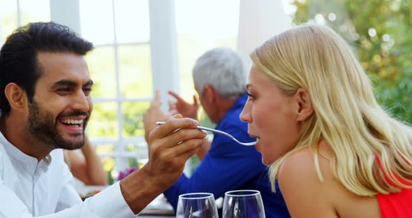 Man feeding woman in restaurant