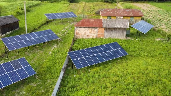 Aerial top down view of solar panels in green rural area.