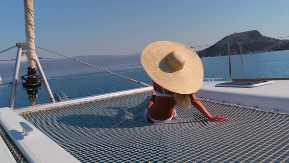 Woman in Bikini Tanning and Relaxing Drinking Wine on a Summer Catamaran Sailing Cruise