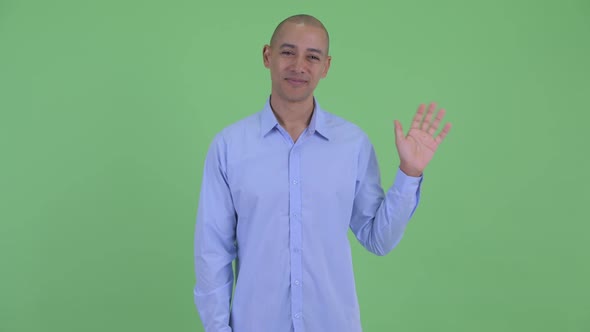 Happy Bald Multi Ethnic Businessman Waving Hand