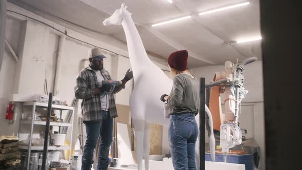 Diverse Artisans Making Giraffe Statue Together