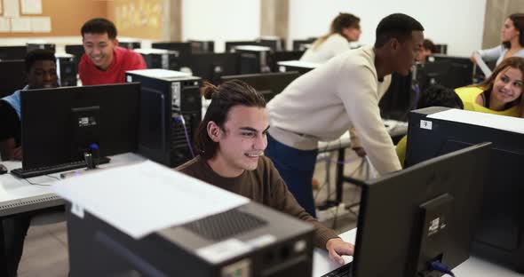 Young multiracial students using computer inside classroom at university