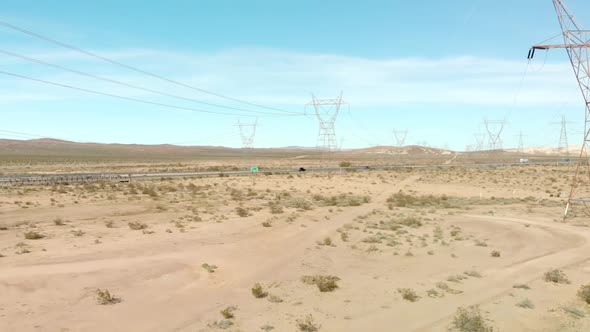 Aerial view backwardement shot of a highway for trucks parallelly beside a road for cars followed by