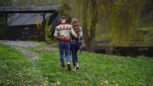 Romantic couple walk outside hugging each other. 