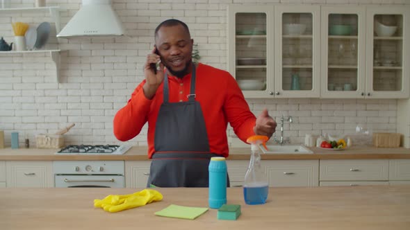 Cheerful African Man Talking on Cellphone During Cleanup