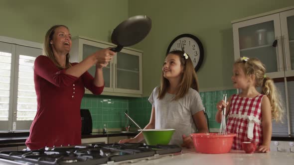 Mother and daughters cooking crepes together