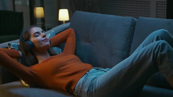 Young Woman is Lying at Home on the Couch with her Eyes Closed