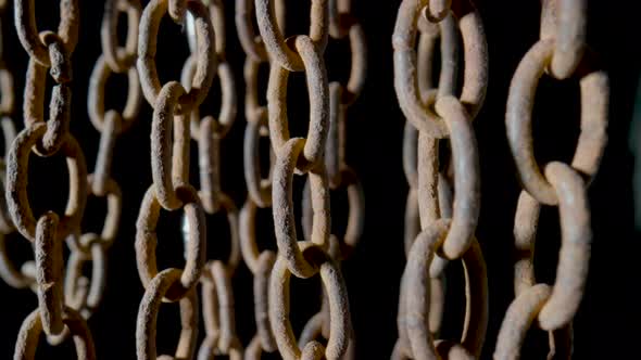 Old Metal Chain with Dark Rusted Links on Black Background