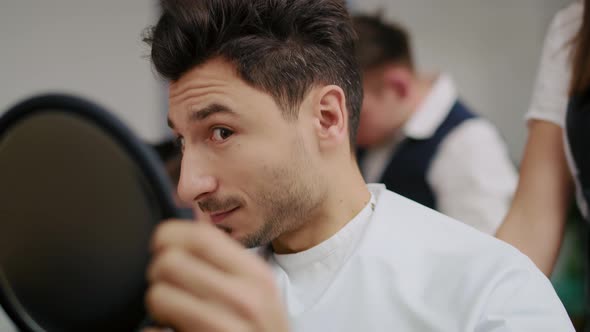 Handheld view of handsome man in hair salon. Shot with RED helium camera in 8K