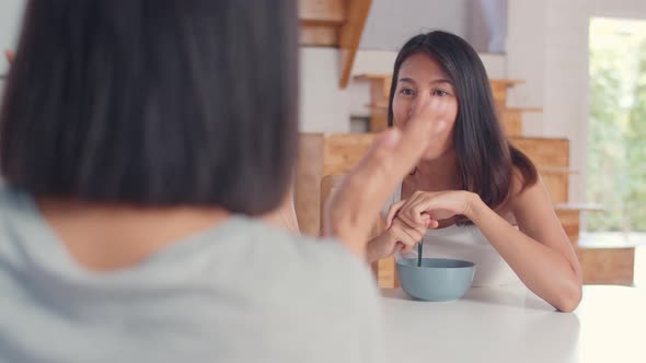 young Asia friend girls feeling happy fun talking together while have breakfast in kitchen.