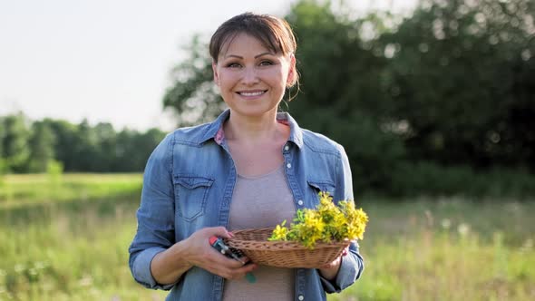 Portrait of Middle Aged Woman with Fresh Cut Flowers of St