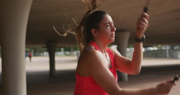 Caucasian woman working out under a bridge