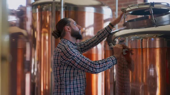 Concentrated Engineer Repairing Large Beer Tank in Brewery