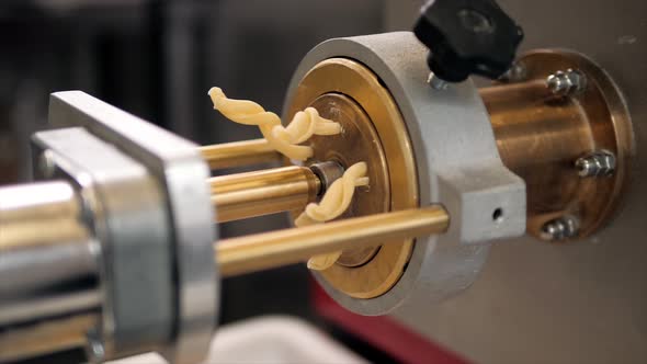 Tortiglioni Cazarece Spaghetti Pasta Falling From a Spout As They Travel Along the Production Line