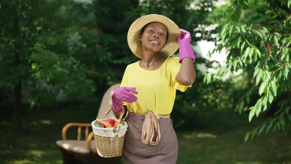 Portrait of Proud Confident African American Gardener Posing in Slow Motion with Vegetable Basket