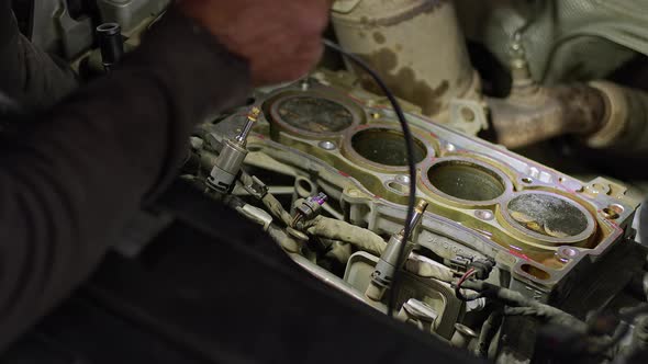 Car Master Checks The Car's Cylinders With The Help Of A Lamp 2