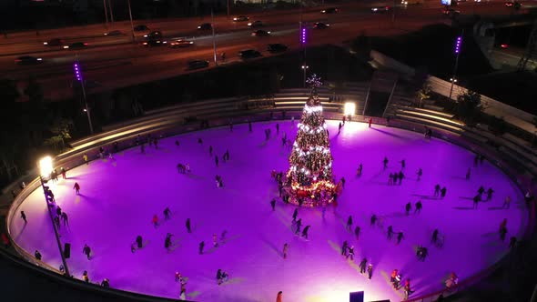 People Skate on the Rink Around New Year's Tree