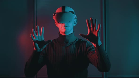 Young Man in a VR Helmet Interacts with Virtual Reality and 360 Media Content